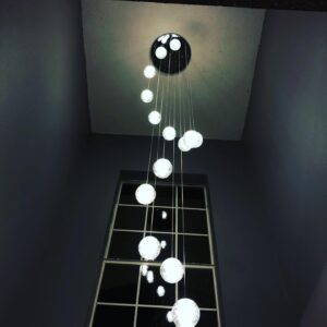 Unique dangling light fixture installed on high vaulted ceiling